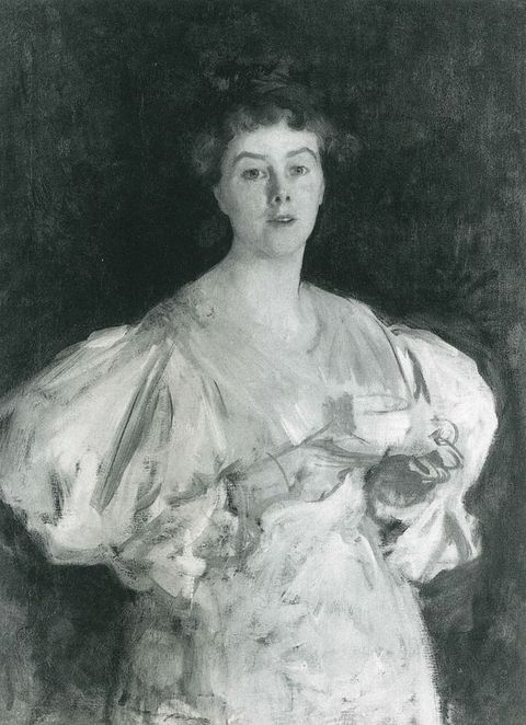 Black and white photograph. This reproduction shows a woman from the hips up. Her peaked eyebrows are raised over clear eyes, and her lips parted so her upper teeth show. Her white or light dress is sketchily painted.